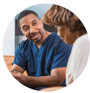 A healthcare professional in scrubs providing support to a patient.